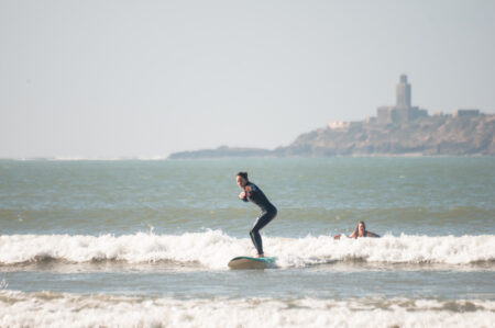 girl surfing at Essaouira beach with surf lesson by Loving Surf school