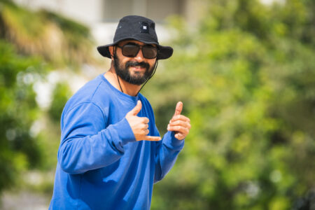 Loving Surf team member walking the beach and smiling at Photographer with shakras