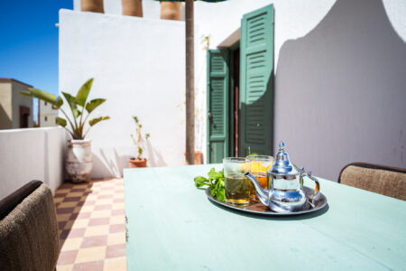 LOVING SURF SALTY BOUTIQUE HOTEL ESSAOUIRA MOROCCO-6379 Moroccan tea on table in co-working space of the Salty hotel in Essaouira Morocco on sunny balcony