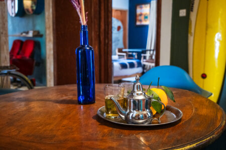 LOVING SURF SALTY BOUTIQUE HOTEL ESSAOUIRA MOROCCO-6387 Moroccan tea on table in co-working space of the Salty hotel in Essaouira Morocco decorated with surfboard and fun art