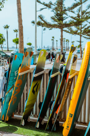Kite boards lined up outside with palm trees in background in Essaouira, Morocco at Loving Surf School