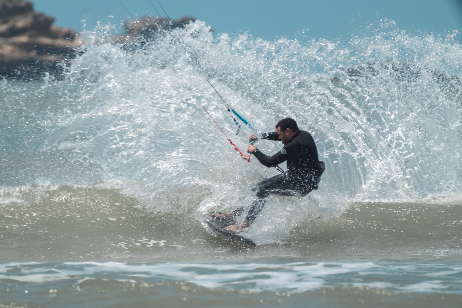 Loving Surf owner strapless kitesurfing and creating massive spray in essaouira bay beach in Morocco